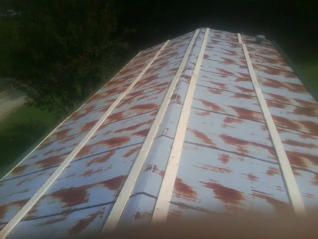 Rusted metal roof panels with new wood purlins before replacement — Storm Damage Roof Repair in Terrace Park by Roofing Brothers