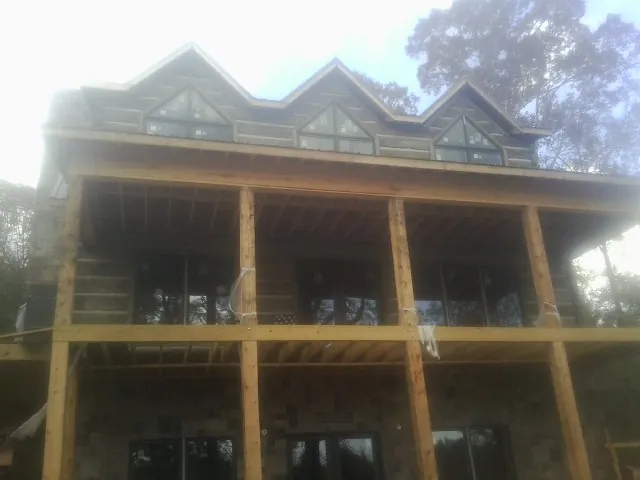 Dormers and porch framing on a large log home under construction — Roof Coating work by our crew in Terrace Park