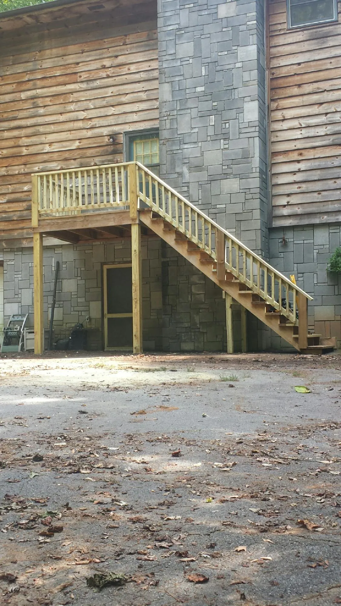 New pressure treated deck and stair landing on a log home in Terrace Park