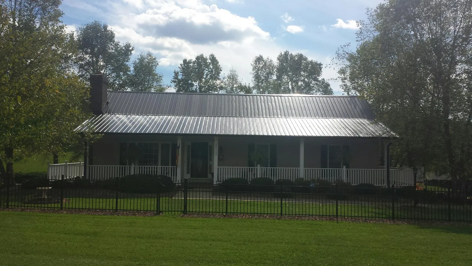 Gray metal roof on a brick ranch with a full width front porch — Gutter Guard Installation work by our crew in Terrace Park