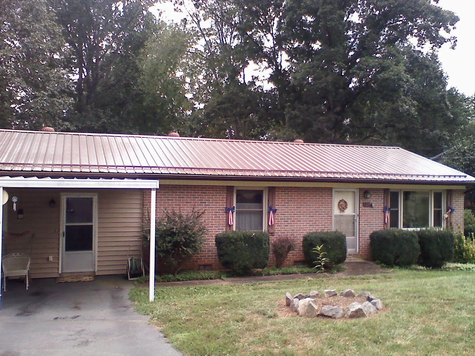 Bronze metal roof and carport on a brick ranch home — Roof Repair work by our crew in Terrace Park